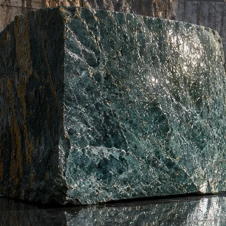 Bloco bruto de pedra verde profundo com veios escuros, molhado na pedreira